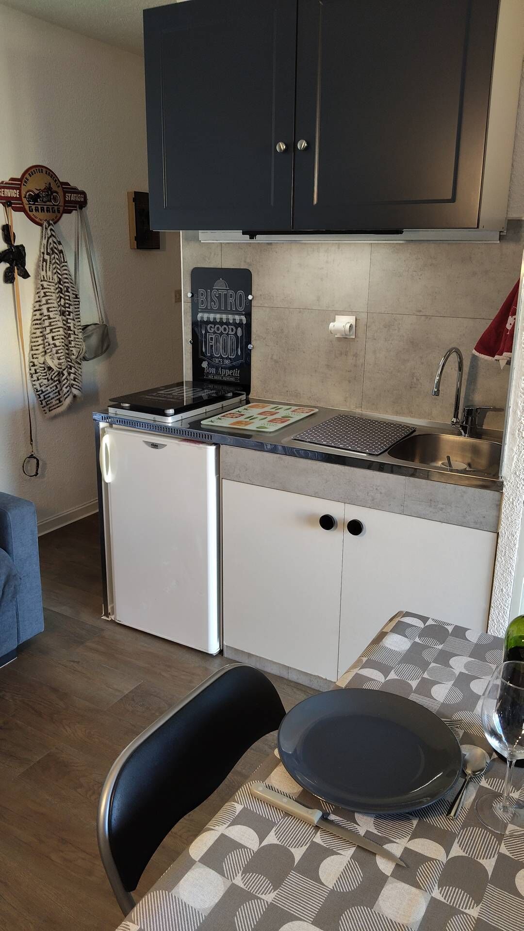 Een koelkast, een microgolfoven, een oven, kookgerei, borden en bestek