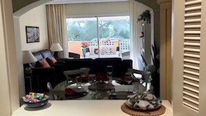 Une cuisine dotée d’un plan de travail en granit, d’une fenêtre offrant une vue sur les bâtiments, d’un coin repas avec une table et des chaises, et d’une variété d’ustensiles de cuisine disposés sur le plan de travail.