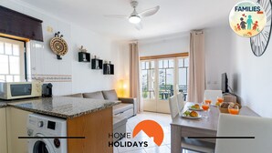 Una cocina moderna con microondas, lavadora y comedor con mesa lista para el desayuno.