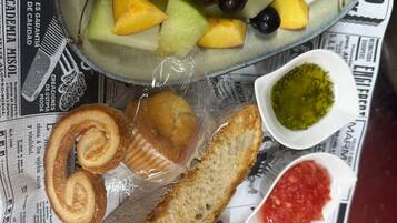 Une assiette remplie d’un assortiment de fruits et de fromages, posée sur un journal.