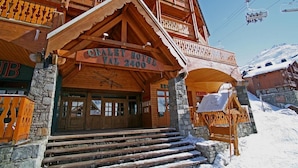 Un hôtel-chalet en bois, sur lequel on peut lire l’inscription « Chalet Hotel Val 2400 ».