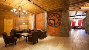 Un hall d’entrée accueillant, agrémenté d’une grande horloge murale, de meubles en bois et d’un lustre.