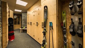 Un chalet de ski doté de casiers en bois, de paires de skis et de bâtons de ski.
