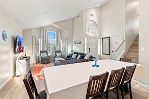 A spacious living area with a dining table, chairs, a sofa, and a television. - Sparkling SaltwtrPool•Spa•Firepit•Netflix•NFL+ (Phoenix)