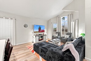 A modern living room with a flat-screen TV, grey sofas, a coffee table, and a patterned rug. - Sparkling SaltwtrPool•Spa•Firepit•Netflix•NFL+ (Phoenix)
