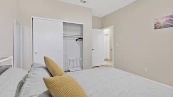 Ein Schlafzimmer mit einem Bett, einem Kleiderschrank und einem Flur, der zu einem weiteren Raum führt.