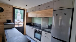 Eine moderne Küche mit Holzelementen, einem Backofen und einem Kühlschrank.