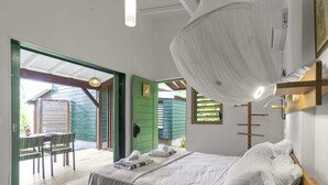 Une chambre à coucher avec un lit, un luminaire suspendu et une vue sur l’extérieur.