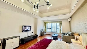 Een moderne hotelkamer met een groot bed, een televisie, een bureau, een stoel en een bank.