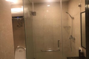 Bathroom features a glass-enclosed shower with handheld showerhead and wall-mounted faucet.