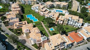 Ett bostadsområde med flera hyreshus, en central pool och välskötta grönområden.