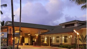 Ein Hotel mit überdachtem Außenbereich, Palmen und einem gut beleuchteten Eingang.