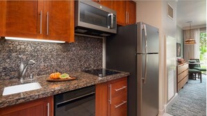 Eine Küche mit Granit-Arbeitsplatten, Edelstahlgeräten, Holzschränken und einem integrierten Geschirrspüler.