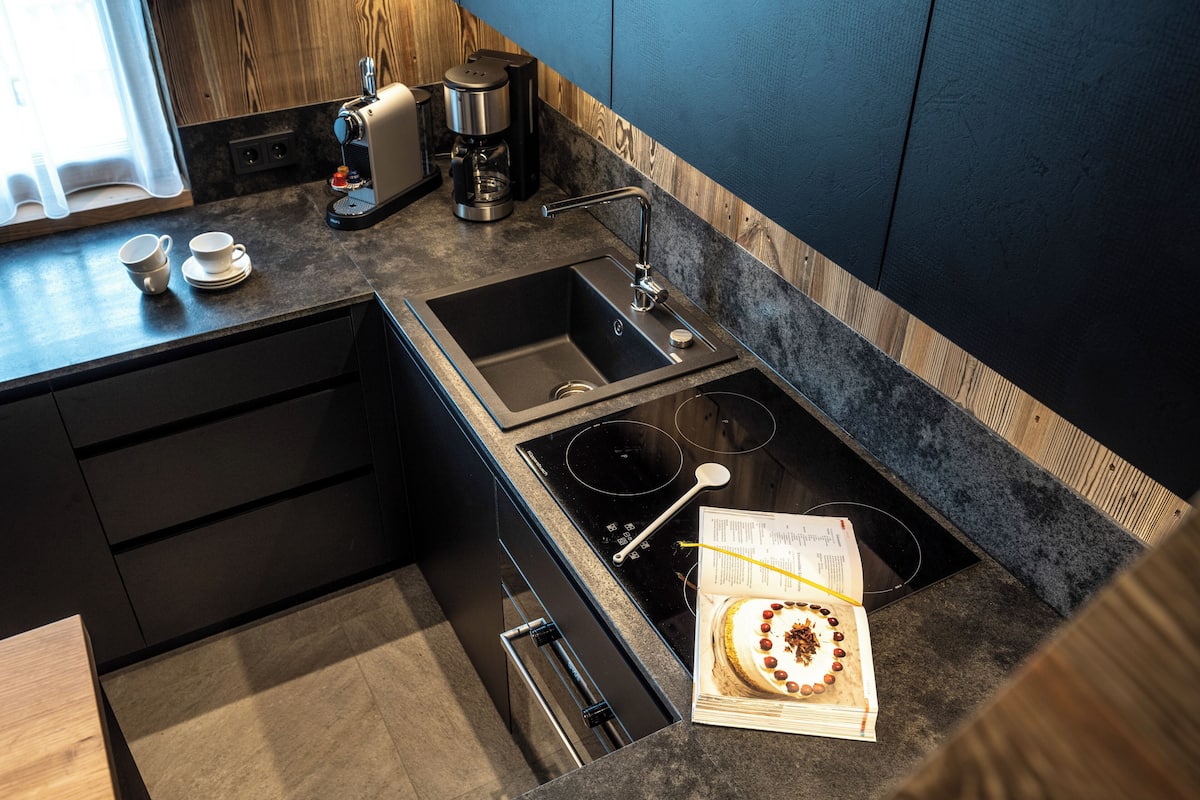Eine moderne Küche mit integriertem Spülbecken, Herd und Kaffeemaschine.