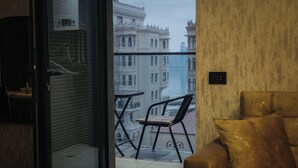 Un balcone con vista su edifici storici, una sedia e un divano.