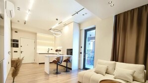 Un soggiorno moderno con un divano, un tavolino da caffè e una zona pranzo con sedie.