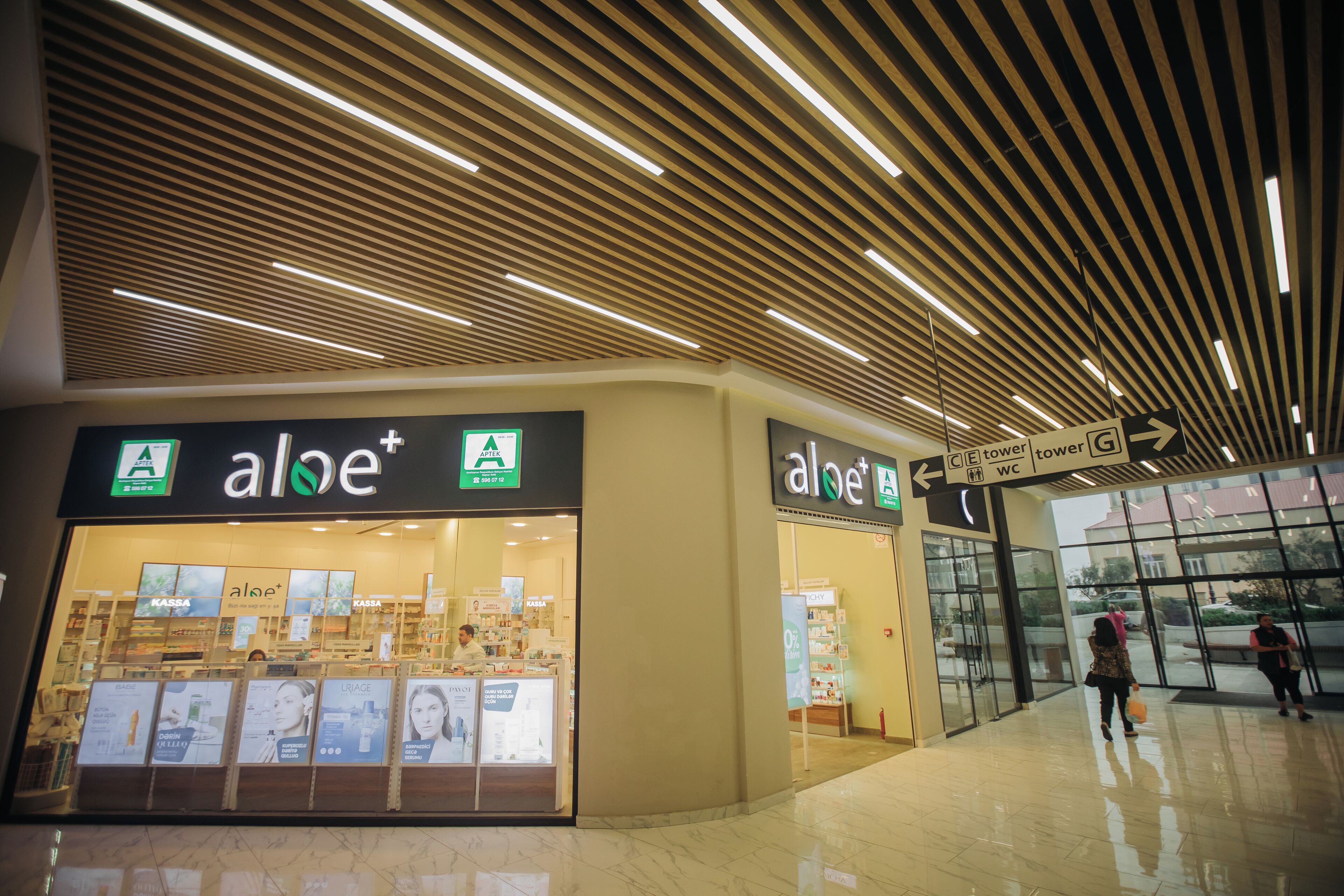 Een modern winkelcentrum met een aloe+ winkel, met een schoon, goed verlicht interieur en duidelijke bewegwijzering.