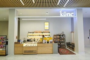 Una tienda moderna con un mostrador de madera, estanterías llenas de productos y un letrero que dice 'küne'.