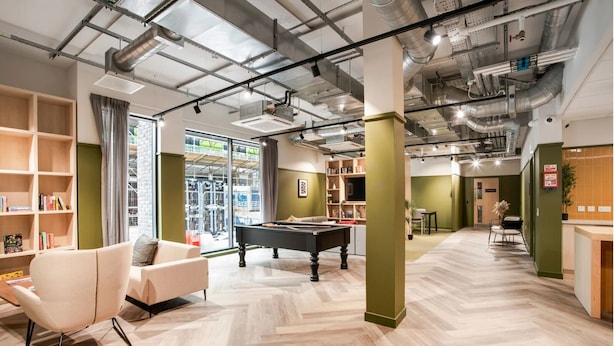 Un intérieur moderne avec une table de billard, des étagères et une vue sur l’extérieur.