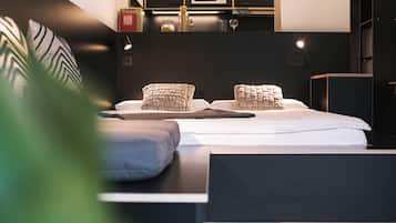 Une chambre à coucher moderne avec un lit bien fait, une table de chevet et une bibliothèque intégrée.