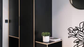 Um guarda-roupa preto com espelho e um vaso de planta em cima.