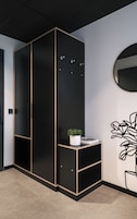 A black wardrobe with a mirror and a potted plant on top.