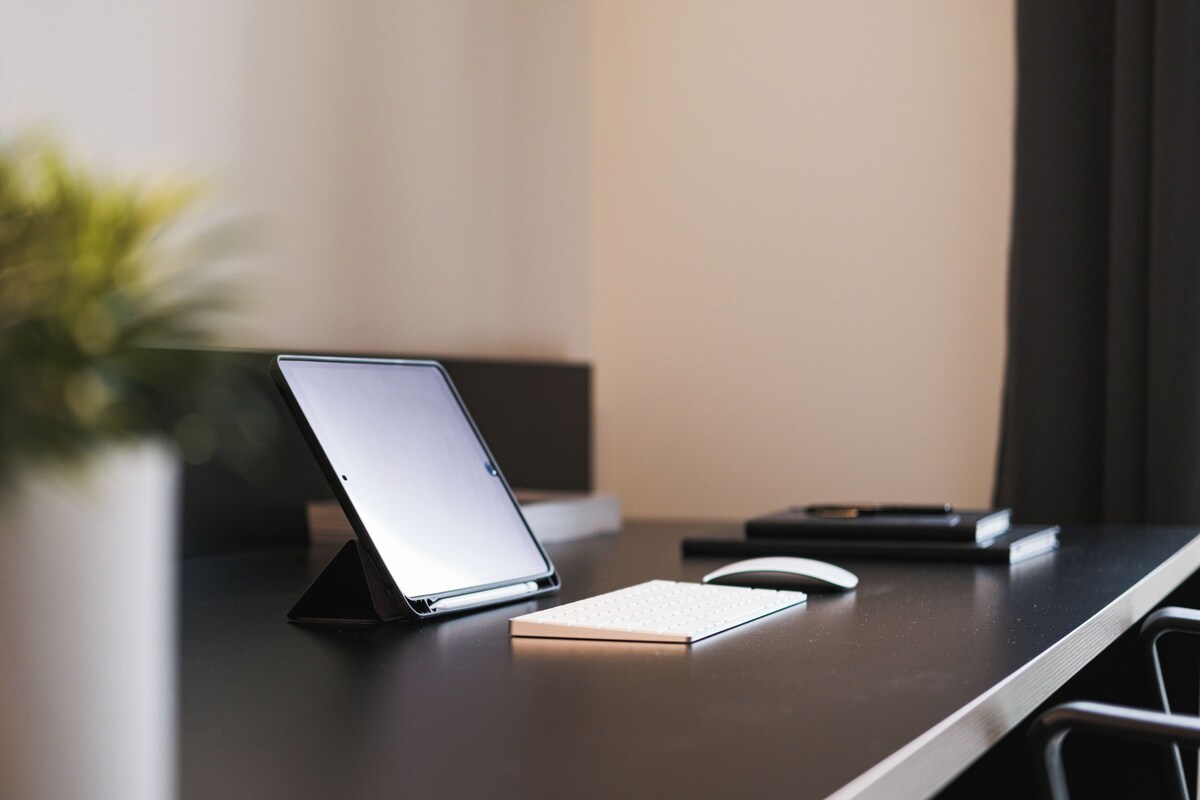 A laptop on a desk with a keyboard and a mouse.