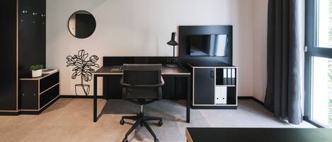 Un espacio de oficina moderno con escritorio, silla, televisor y estanterías.