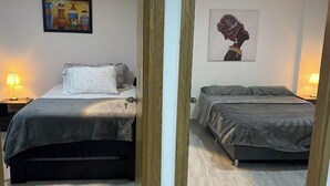 Une chambre à coucher avec un lit, une table de chevet, une lampe et un tableau au mur.