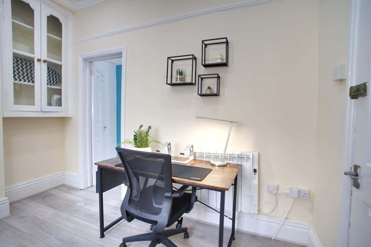 Une pièce comprenant un bureau, une chaise et une lampe fixée au mur.