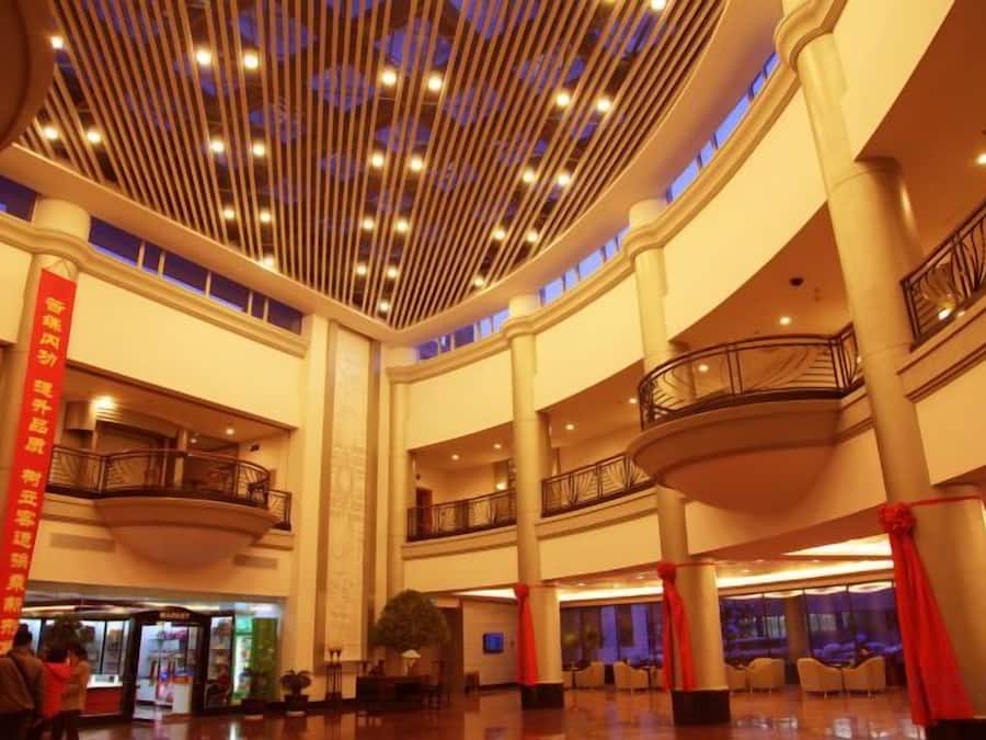 A multi-level atrium with a high ceiling, balconies, and a central column with a red banner.