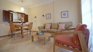 A living room with a sofa, a coffee table, and a dining area with chairs and a table. - Albatros 23 - Two Bedroom Apartment, Sleeps 5 (Punta del moral)