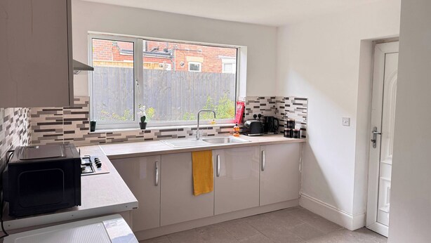 A modern kitchen with a window, a microwave, a toaster, and a kettle. - City Centre-4 Br-sleeps 7-garden-free Parking (Newcastle-upon-Tyne)
