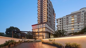 A high-rise hotel with a modern design, featuring a prominent entrance and a well-maintained outdoor area with potted plants. - Ramada by Wyndham Ranchi (Ranchi)