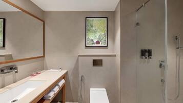 Ein modernes Badezimmer mit großem Spiegel, Waschbecken, Toilette und Dusche.