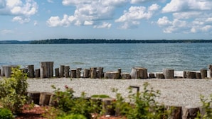 A calm lake with a wooden dock and a gravel path leading to it. - Goffatt Island-your private island  2-Bedroom Cabin 204 (Goffatt Island)