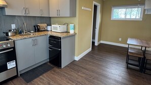 A modern kitchen with grey cabinets, a microwave, and a dishwasher. - Goffatt Island-your private island  2-Bedroom Cabin 204 (Goffatt Island)