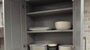 A kitchen with grey cabinets, a white countertop, and a stainless steel stove.
