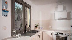 A modern kitchen with a window, sink, and stove. - Seaside Villa Angel - Samos Cozy Getaway (Samos)