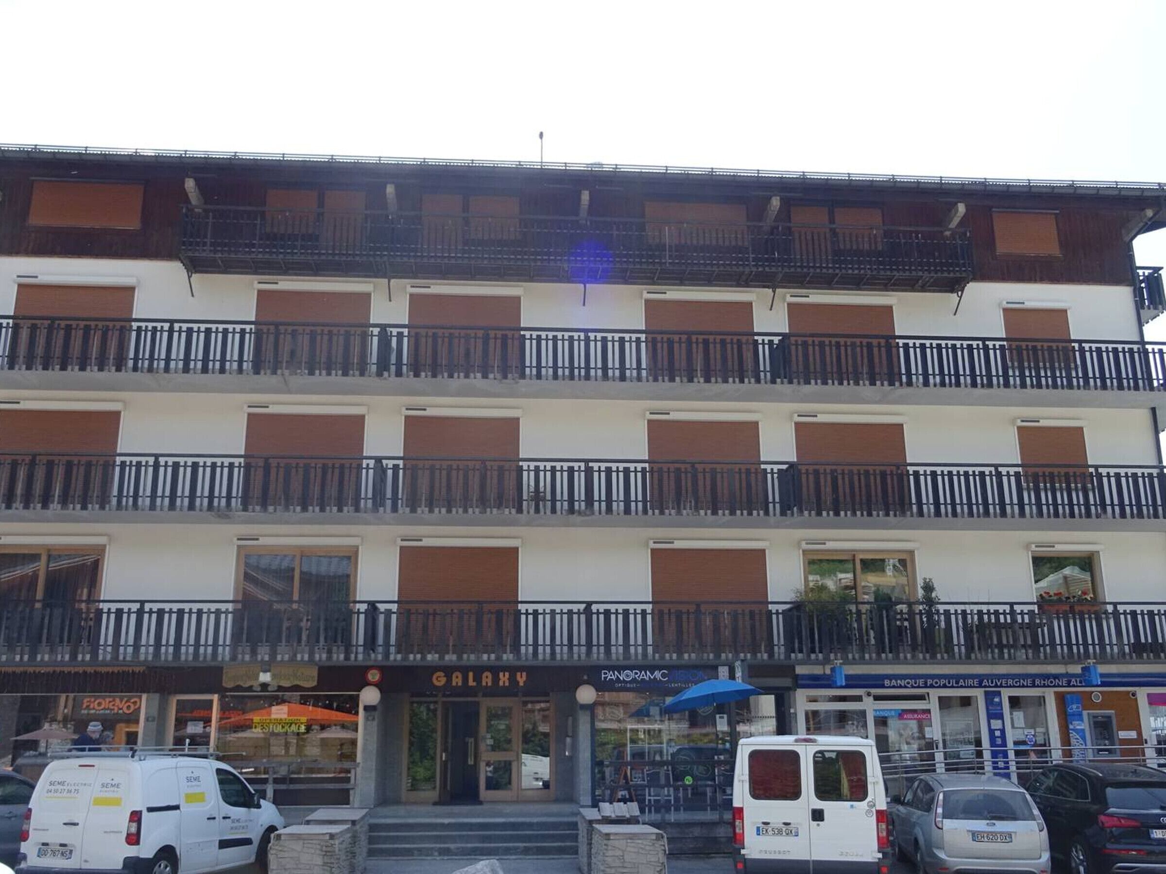 A multi-story building with balconies and a storefront named "GALAXY".
