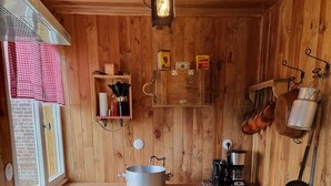 A rustic wooden kitchen with a large pot on the counter, a coffee maker, and hanging pots. - La Germaine - wooden shack in the countryside (Ribécourt-Dreslincourt)