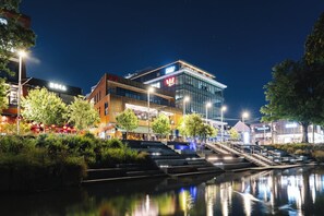 A modern building with a glass facade and a sign reading "AIA". - Designer Urban Escape | Stylish City Comfort (Christchurch)