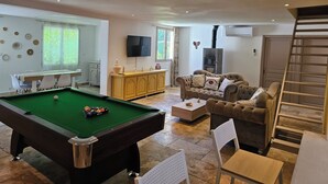 A spacious living area with a pool table, a comfortable sofa, and a television. - Country House (Caumont-sur-Durance)