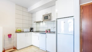 A modern kitchen with white cabinets, a microwave, a refrigerator, and a dishwasher. - Apartment in Roses near Nova Sandy Beach (Rosas / Roses)