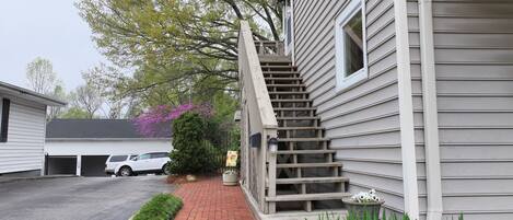 A residential property with a garage, a staircase leading to the entrance, and a brick pathway.
