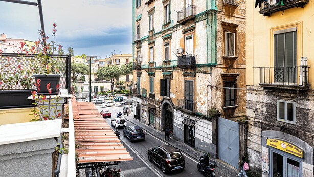 A street view with a building featuring a sign for 'Il Lindo dei Sensi Abbraccianti'. - Alyde Apartments (Naples)
