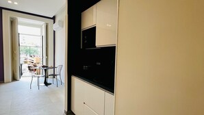 A modern kitchen with white cabinets, a black countertop, and recessed ceiling lights. - Alyde Apartments (Naples)