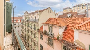 A narrow street with buildings featuring ornate balconies and red-tiled roofs. - GuestReady - Downtown Charming Stay (Lisbon)