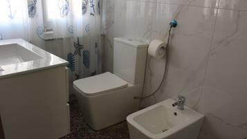 Un bagno con il water, bidet e lavandino.