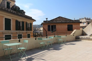 A rooftop terrace with outdoor seating and a view of the cityscape. - Genova Antica (Genoa)